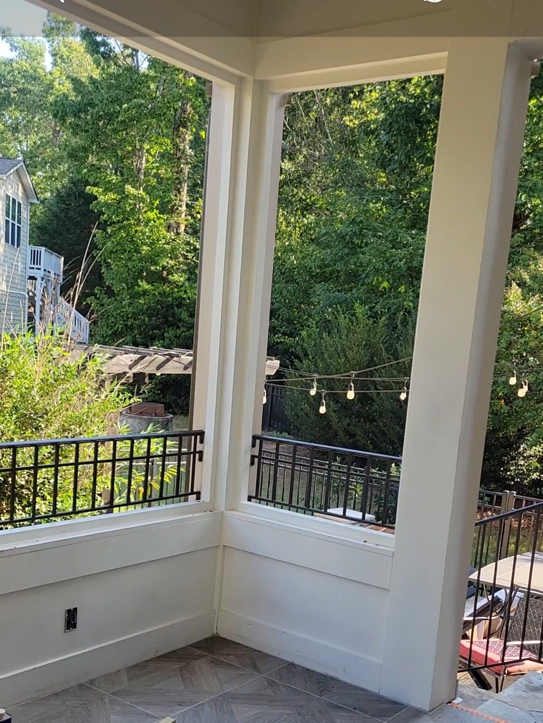 Black metal porch railing framing a shaded residential porch