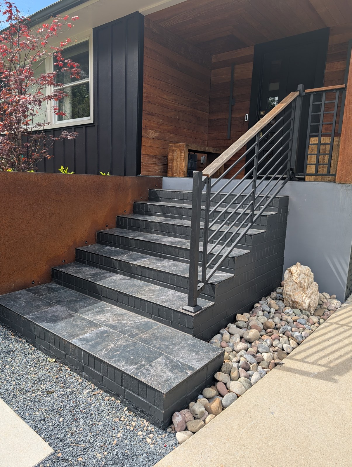 Black metal handrails flanking wide gray front entry steps